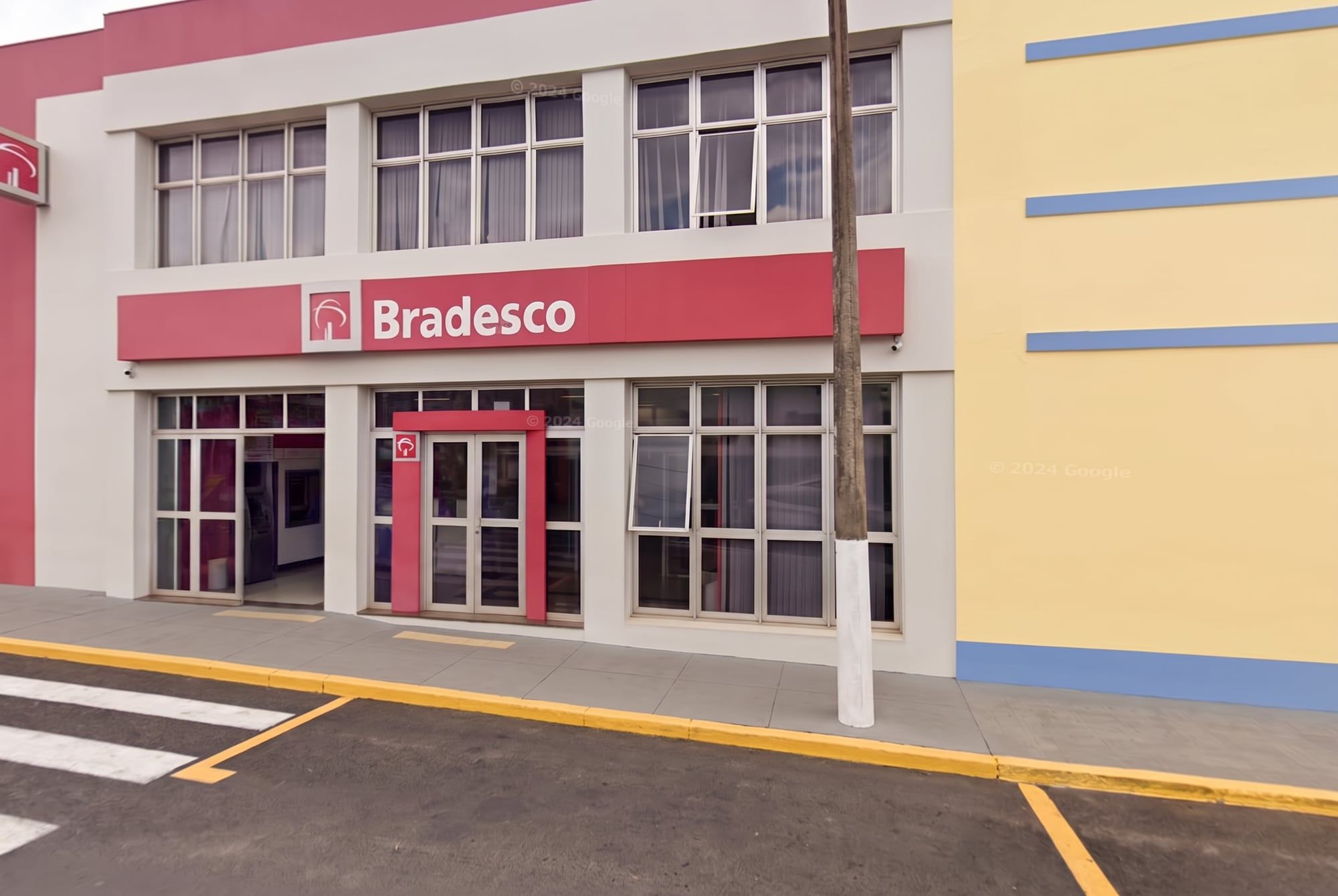 Fachada de prédio comercial de dois andares com vitrines, no Centro de Cafelândia, SP